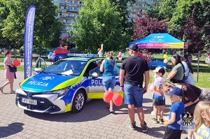 Na zdjęciu uczestnicy festynu przy radiowozie.