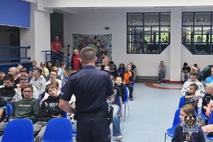 Na zdjęciu policjant w trakcie prowadzenia pogadanki z uczniami.