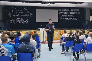Na zdjęciu policjant w trakcie prowadzenia pogadanki z uczniami.