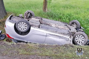 Na zdjęciu strażacy oraz samochód, który dachował w rowie.