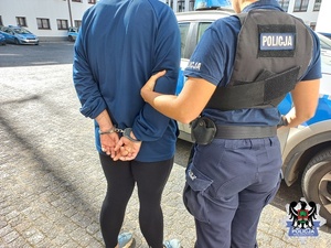 policjanta pilnuje zatrzymaną poszukiwaną