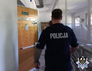 policjant z ztarzymym po opuszczeniu policyjnej celi