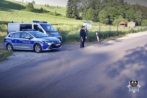 Na zdjęciu radiowozy oraz policjant.