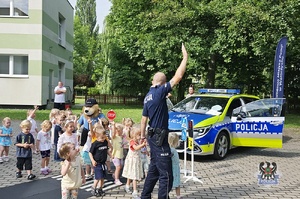 Na zdjęciu policjant w trakcie spotkania z młodymi mieszkańcami miasta.
