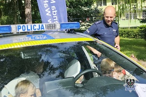 Na zdjęciu policjant w trakcie spotkania z młodymi mieszkańcami miasta.