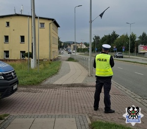 Policjant z radarem przy drodze
