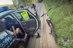 Na zdjęciu radiowóz oraz policjant wsiadający do radiowozu.