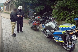 Na zdjęciu policjant podczas kontroli kierujacego oraz motocykl i motorower.