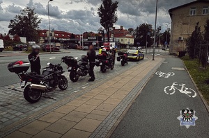 Na zdjęciu radiowóz oraz policjanci podczas kontroli drogowej.