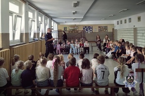 Na zdjęciu policjant podczas spotkanie z uczniami szkoły podstawowej.