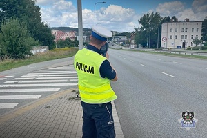 Na zdjęciu policjant z ręcznym miernikiem prędkości.