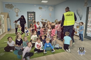 Na zdjęciu policjant w trakcie pogadanki z dziećmi.