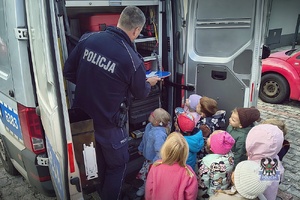 Na zdjęciu policjant w trakcie pogadanki z dziećmi.