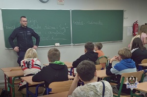 Na zdjęciu policjant podczas spotkania z uczniami.