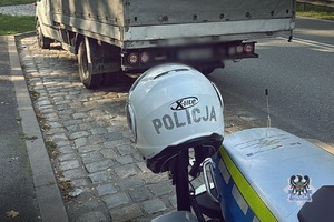 Na zdjęciu kask motocyklisty oraz samochód ciężarowy.