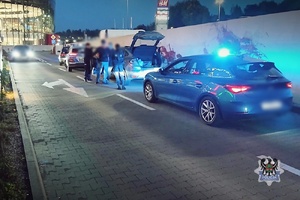 Na zdjeciu radiowozy oraz policjanci podczas kontroli drogowej.