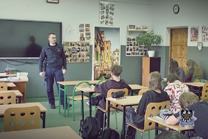 Na zdjęciu policjant rozmawia z uczniami o bezpieczeństwie.