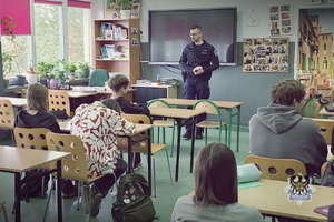 Na zdjęciu policjant rozmawia z uczniami o bezpieczeństwie.