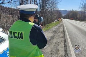 Na zdjęciu policjant z ręcznym miernikiem prędkości.
