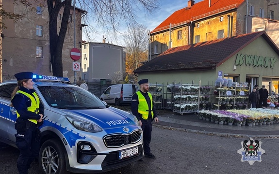 Na zdjęciu policjanci i radiowóz na ulicy.