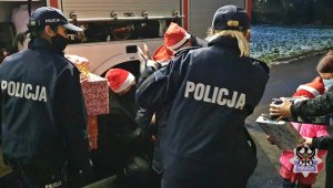 Na zdjęciu mundurowi wręczają prezenty najmłodszym.