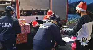 Na zdjęciu mundurowi wręczają prezenty najmłodszym - zdjęcie nr 4.