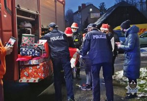 Na zdjęciu mundurowi wręczają prezenty najmłodszym - zdjęcie nr 3.