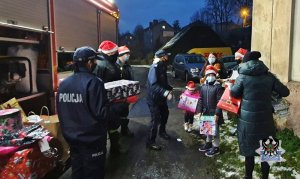 Na zdjęciu mundurowi wręczają prezenty najmłodszym - zdjęcie nr 5.