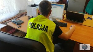 Na zdjęciu policjant w kamizelce z napisem Policja