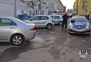 Na zdjęciu policjant na miejscu zdarzenia kradzieży katalizatora.