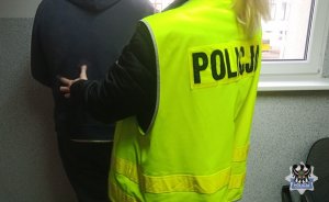 Na zdjęciu policjantka sprawdza jednego z zatrzymanych mężczyzn.