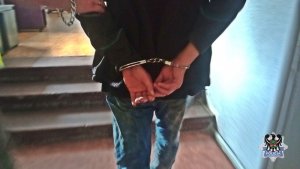 Na zdjęciu zatrzymany mężczyzna z założonymi na ręce kajdankami.