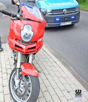 Na zdjęciu radiowóz oraz motocykl biorący udział w zdarzeniu drogowym.