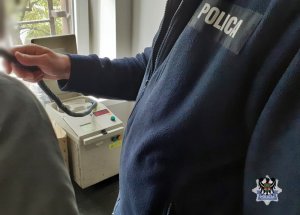 Na zdjęciu policjant sprawdza stan trzeźwości kierującego.